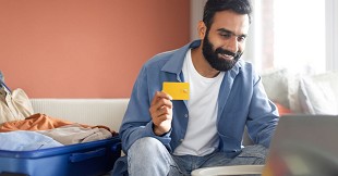 How should you use credit cards for international travel without extra charges?